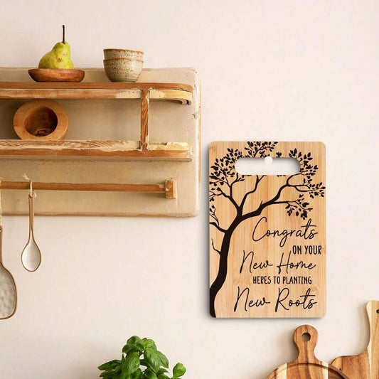 Chic cutting board gift featuring a tree design with text congratulating on a new home and new roots.